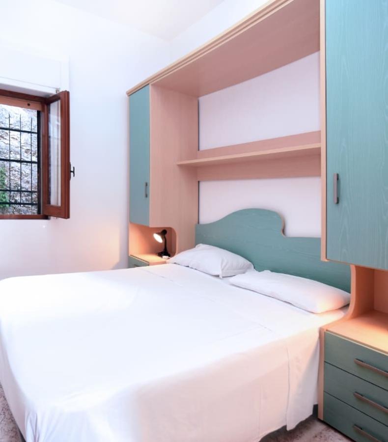 Camera da letto con letto matrimoniale, mobili in legno e finestra aperta.